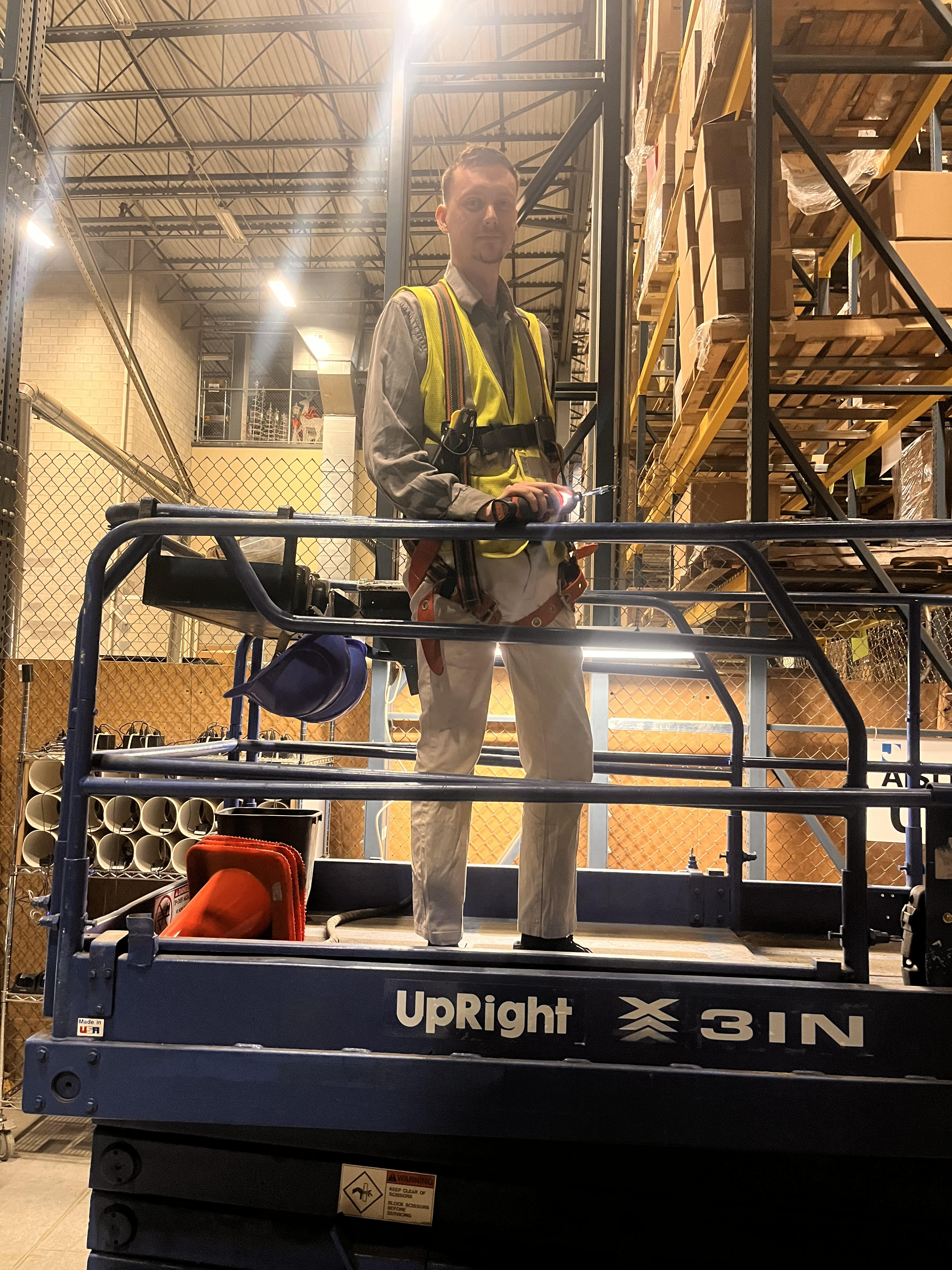 Electrician using a lift for a high-ceiling residential fixture